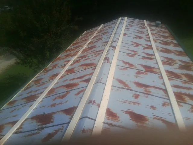 Rusted metal roof panels with new wood purlins before replacement — Storm Damage Roof Repair in Lincoln by Roofing Brothers